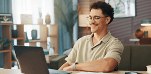 man smiling at laptop